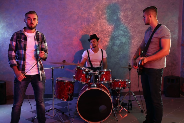 Musicians playing musical instruments and singing songs in a studio