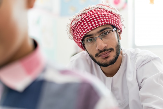 Foto studente arabo musulmano in aula