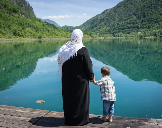 Muslim Arabic mother with her son on the lake