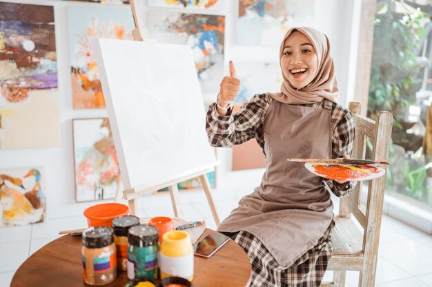 Muslim asian female artist showing thumb up