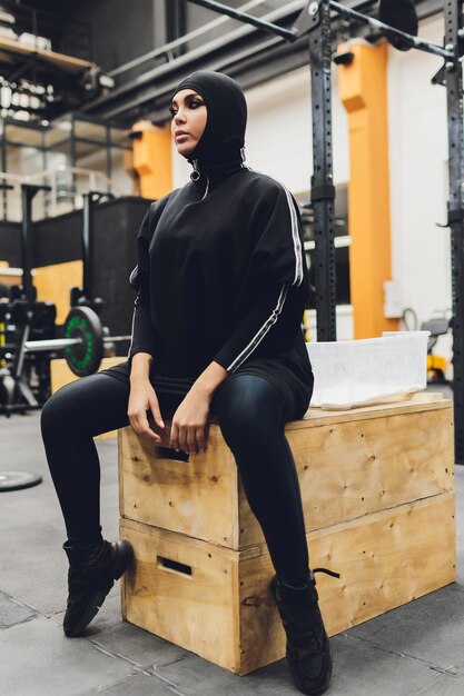 Muslim asian woman in hijab exercizing in a gym