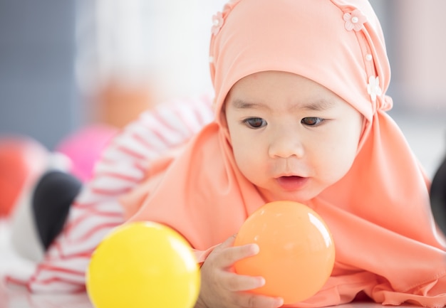 Muslim baby gioca con giocattoli colorati in soggiorno