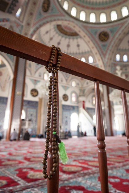 Photo muslim beads hanging on woodem railings in a mosque