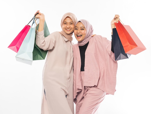 Muslim bestfriend happy holding a shopping bag over white background