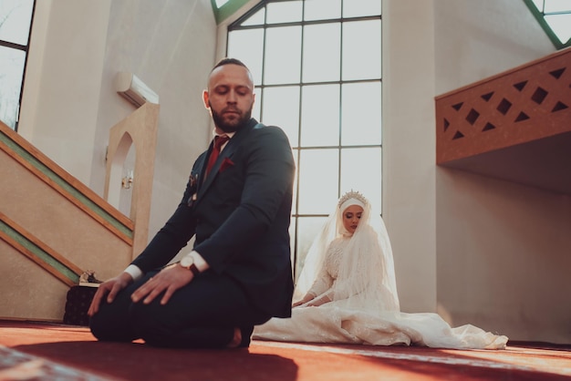 Muslim bride and groom praying at the mosque during a wedding ceremony Selective focus