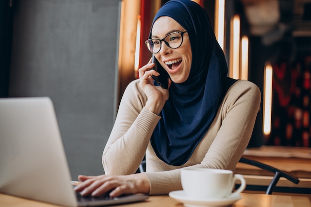 Muslim business woman working on computer in a cafe