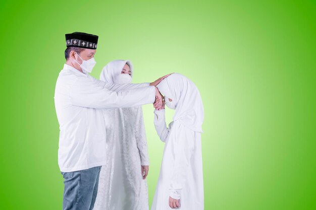 Muslim child in mask apologizing to her parents