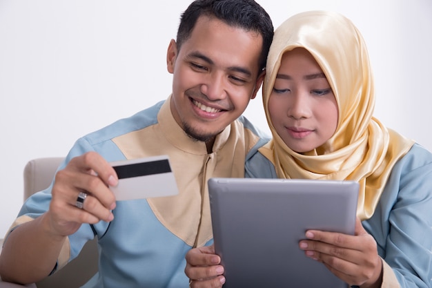 Muslim couple on a couch with tablet