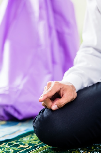 Muslim couple, man and woman, praying at home