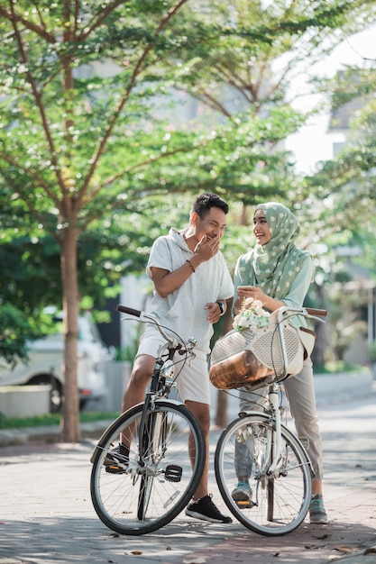 Foto coppia musulmana in sella a una bicicletta