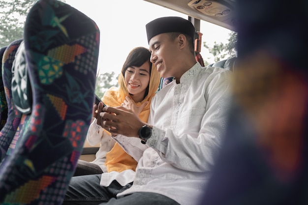 Muslim couple travel by bus during eid mubarak holiday to meet family at home