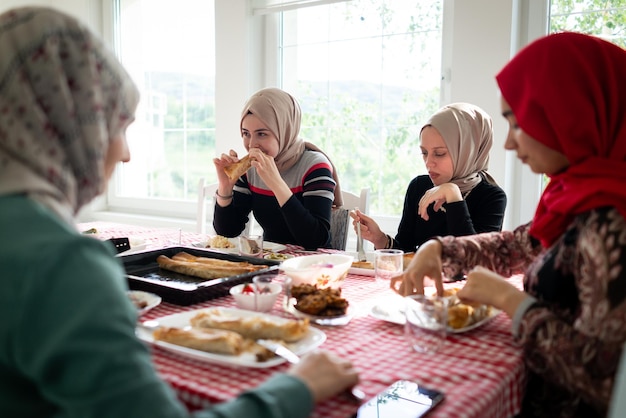 写真 イスラム教徒の家族と友人が家で集まって夕食を食べている 高品質の写真