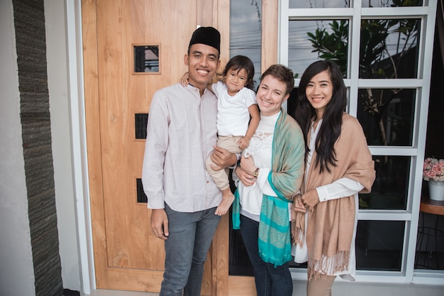 Мусульманская семья и друг улыбаются