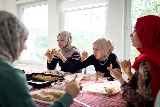 Foto famiglia e amici musulmani che si riuniscono a casa per cenare foto di alta qualità