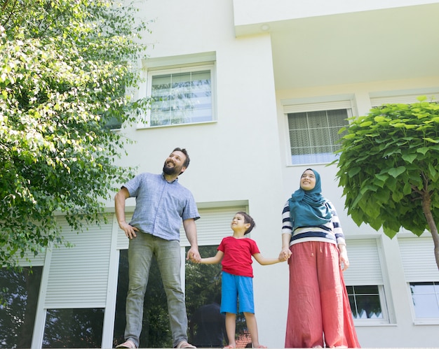 Muslim family in front of beautiful modern house