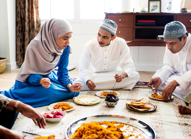 写真 床で夕食を食べているイスラム教徒の家族