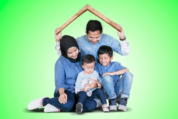 Muslim family plays under a roof symbol on studio