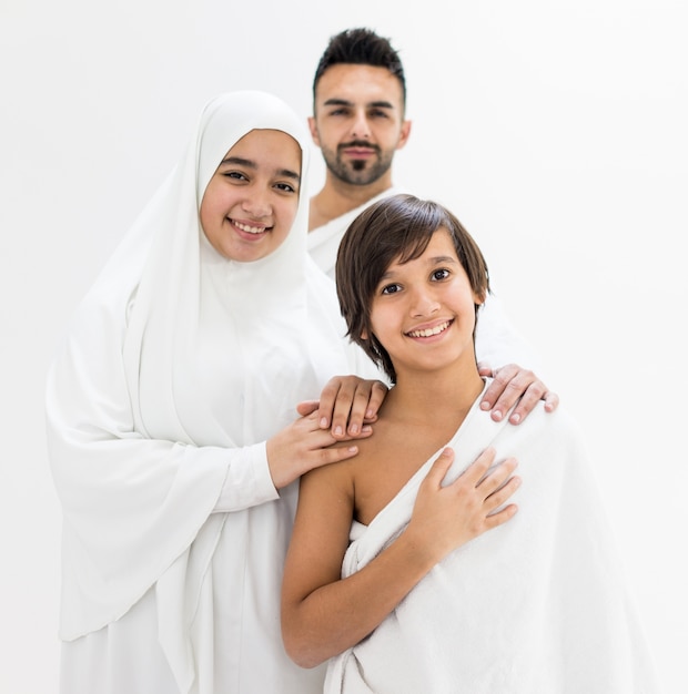 Muslim family posing as ready for Hajj visiting Kaaba in Mecca