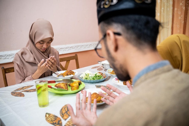 La famiglia musulmana prega e ringrazia dio per il cibo mentre rompe il digiuno