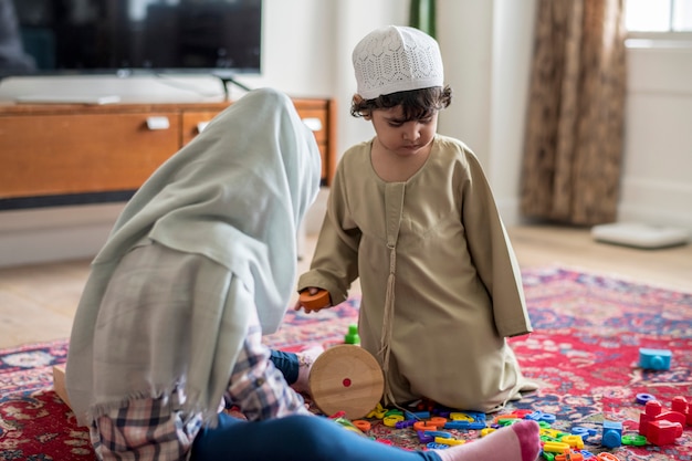 Photo muslim family relaxing and playing at home