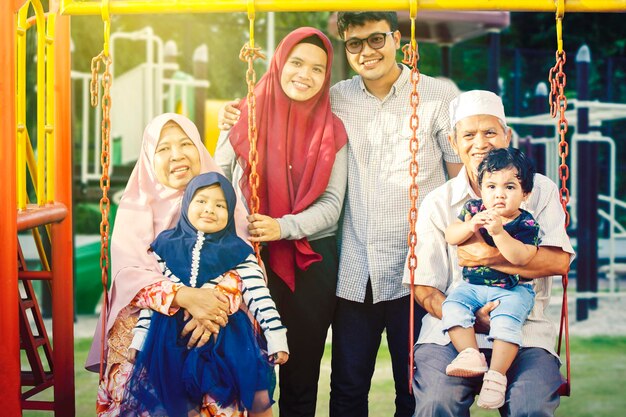 Muslim family smiling at camera in playground