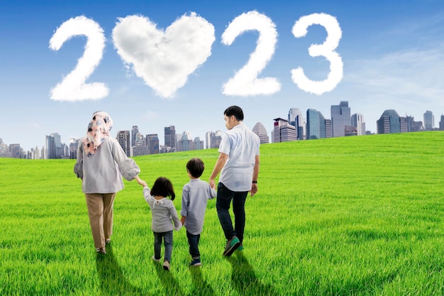 Muslim family walk with clouds shaped 2023 number