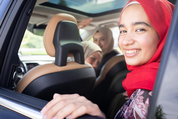 Muslim female friends enjoying road trip traveling at vacation in the car. High quality photo