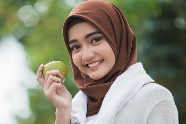 Muslim female sport eating an apple