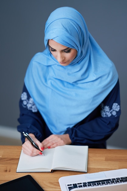 Muslim female student learning in library