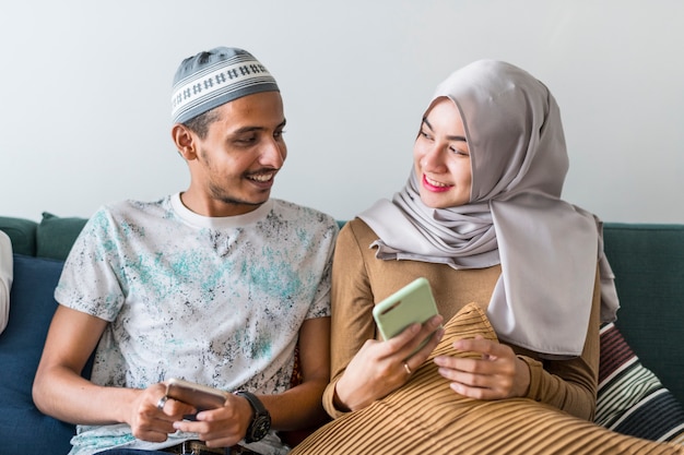 Amici musulmani che utilizzano i social media sui telefoni