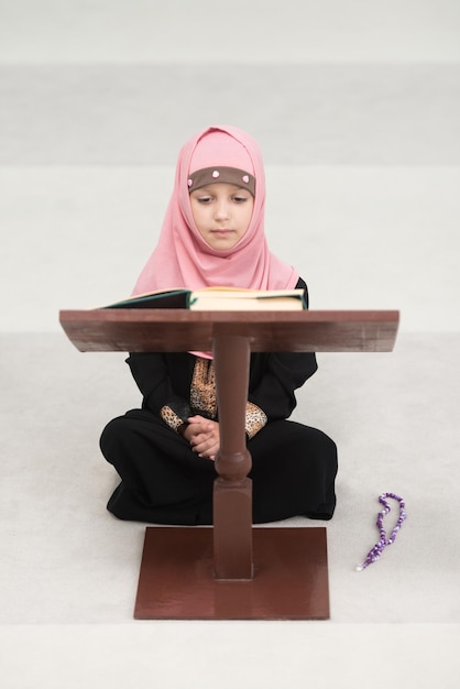 Muslim Girl In Headscarf Is Reading The Quran