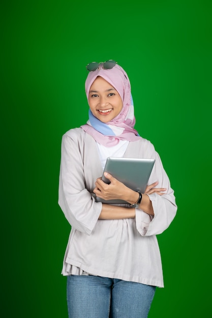 Muslim girl in hijab using a digital tablet with copyspace