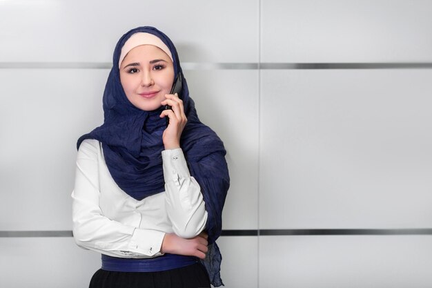 Muslim girl talking on the phone in the office