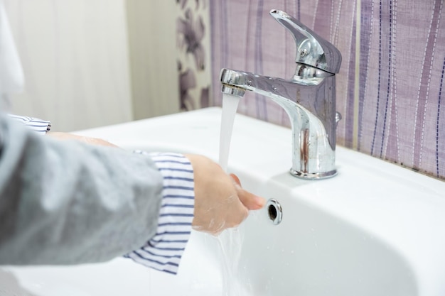 Muslim girl washing her hands in the bathroom