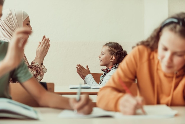 Muslim hijab the teacher plays and hugs the little girl at school Selective focus High quality photo