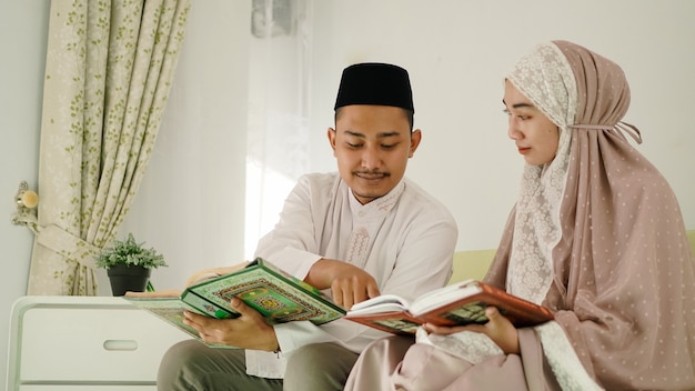 Muslim husband helping his wife read the Quran