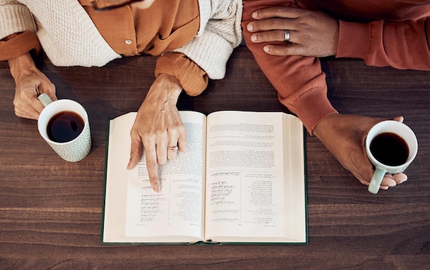 Il corano islamico musulmano e le mani delle donne bevono caffè al mattino con un libro di adorazione e fede vista dall'alto della lettura del testo di speranza e delle informazioni degli amici insieme per la preghiera spirituale e islamica