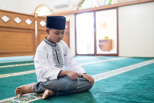 Muslim kid praying in the mosque