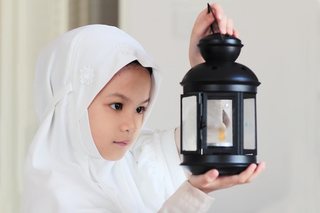 Bambino musulmano che prepara la lanterna per il mese santo del ramadanbambino musulmano asiatico in abito tradizionale felice