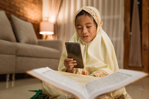 Muslim kid using mobile phone after praying