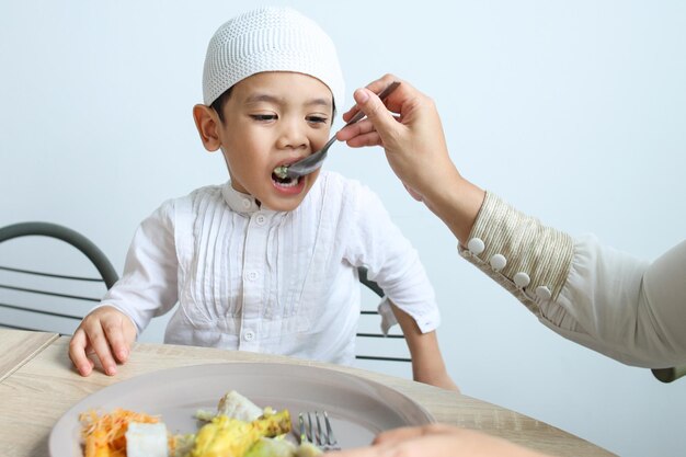 Foto un ragazzino musulmano che si gode il cibo di eid mubarak