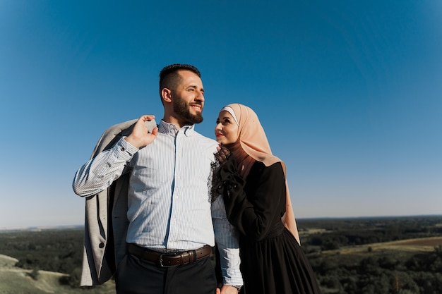 Muslim love story. cheerful mixed couple smiles and hugs.