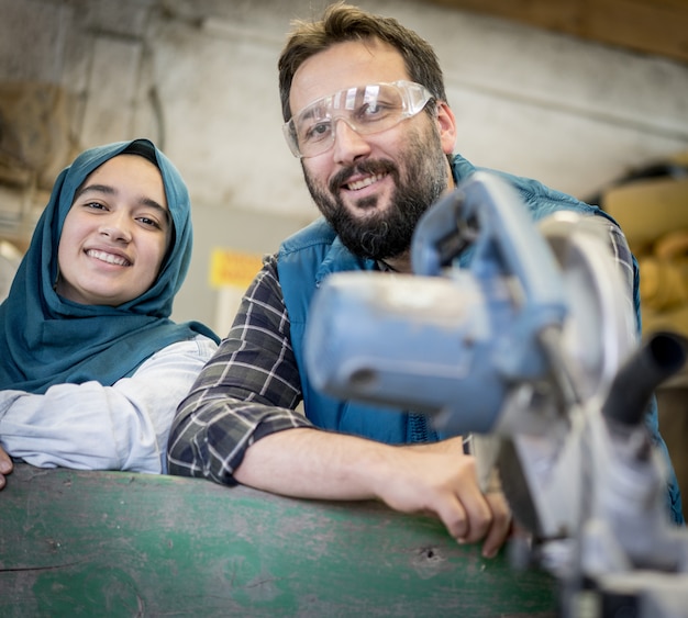 Maschio e femmina musulmani in officina che lavorano insieme