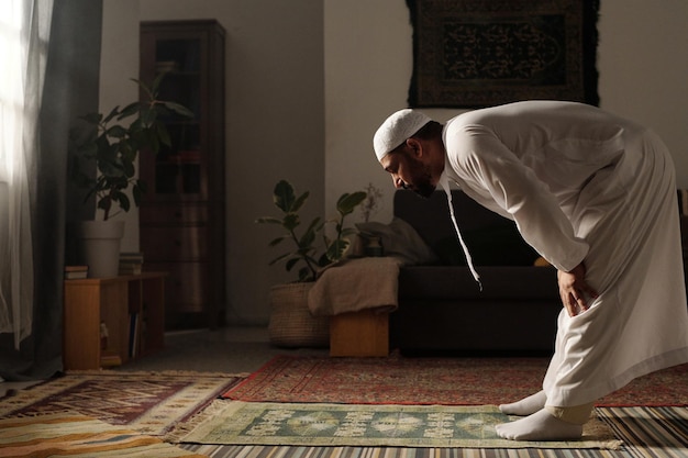 Foto uomo musulmano piegato in avanti durante la namaz