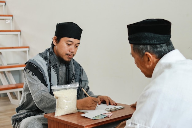 Foto l'uomo musulmano riempire la lista di donatore di zakat durante l'eid mubarak alla moschea musulmani per aiutare i poveri un