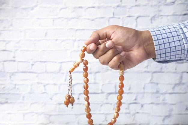 Photo muslim man hand with rosary praying close up