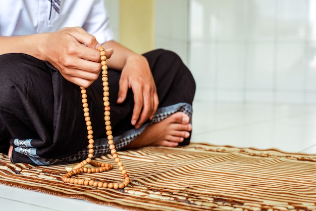 Photo muslim man hands holding rosary to count dzikir