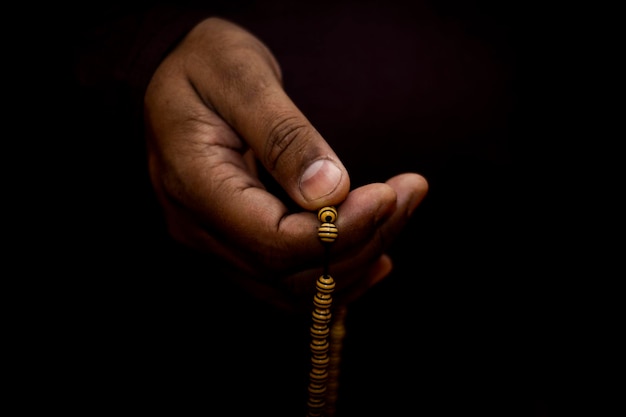 A Muslim man in a headscarf is praying with beats Side view of young Muslim men praying