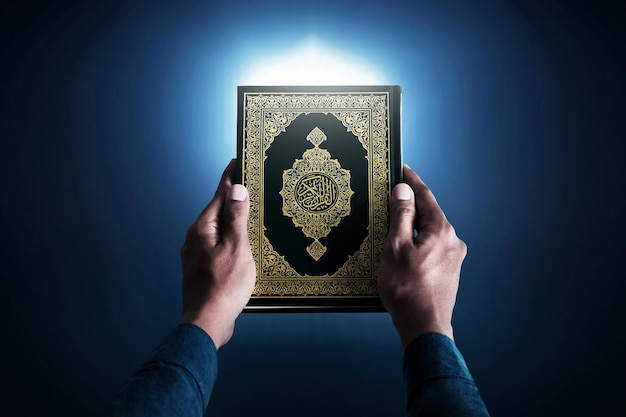 Muslim man holding holy quran