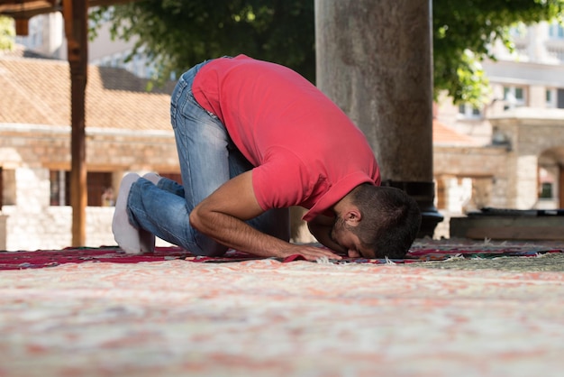 イスラム教徒の男性が屋外のモスクで祈っています